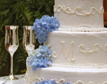 Biały tort ozdobiony niebieską hortensją